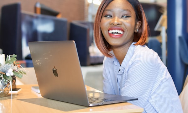 Smiling woman checking her sales on a laptop
