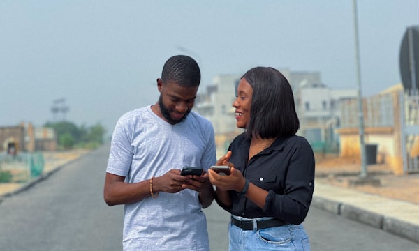 Man and woman smiling at a phone screen together