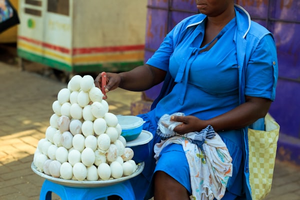 Woman selling a pyramid of fresh eggs at the market