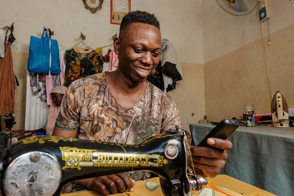 Tailor smiling as he works at his sewing machine