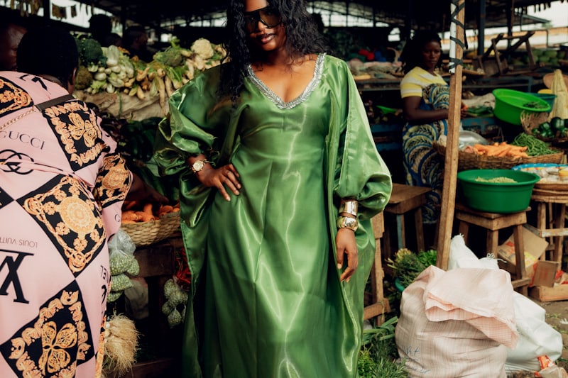 Woman in a green dress shopping at a bustling Accra market